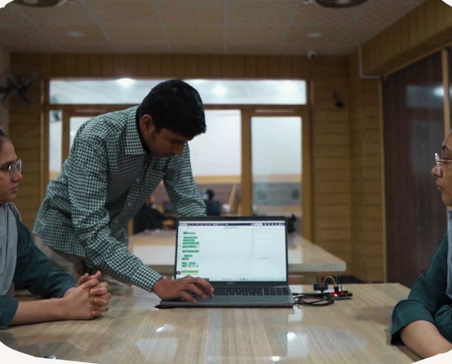 Ahmed teaching students on a laptop at our IT institute